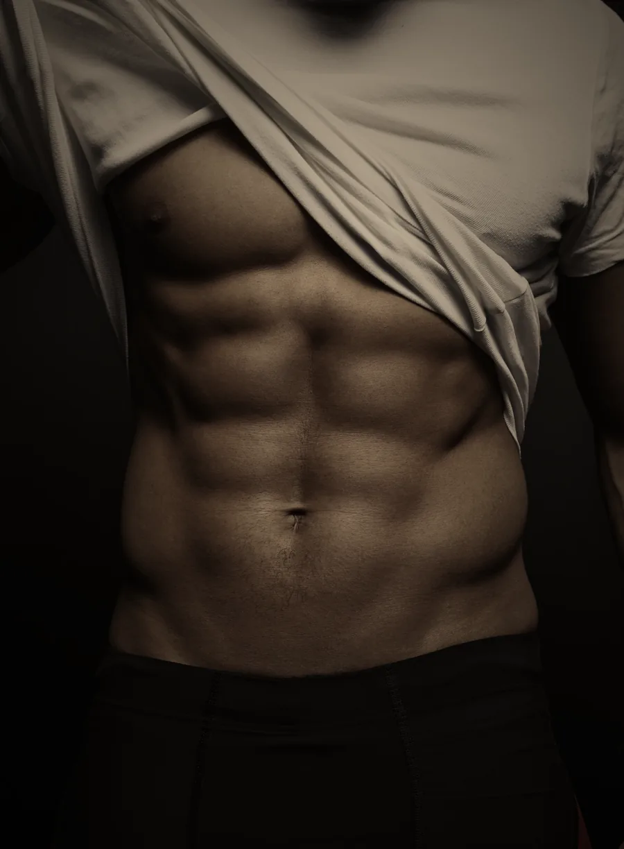 Hombre levantando la camiseta y mostrando abdominales marcados